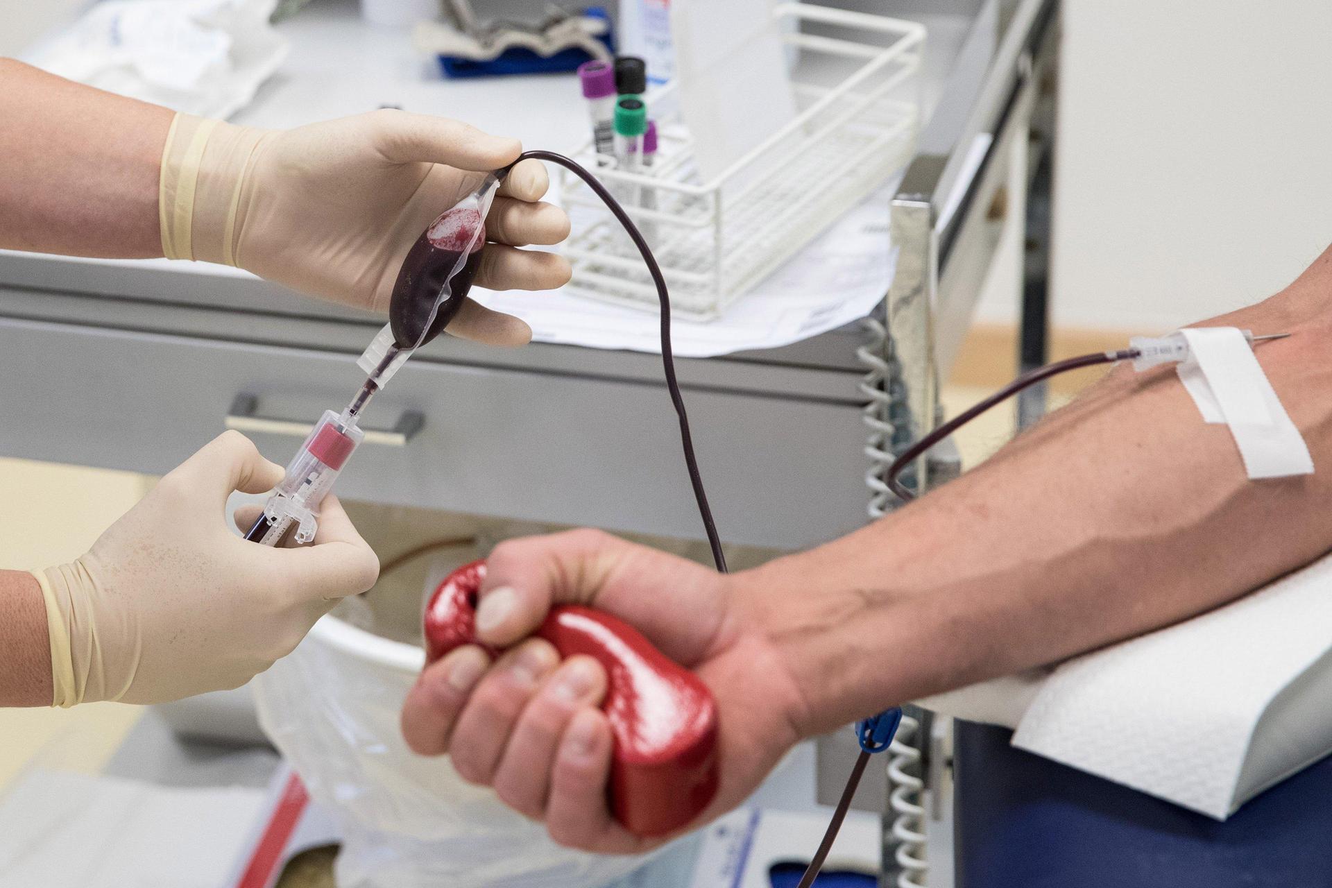 Eine Mitarbeiterin entnimmt einem Blutspender Blut. (Symbolbild: Christian Charisius/dpa)