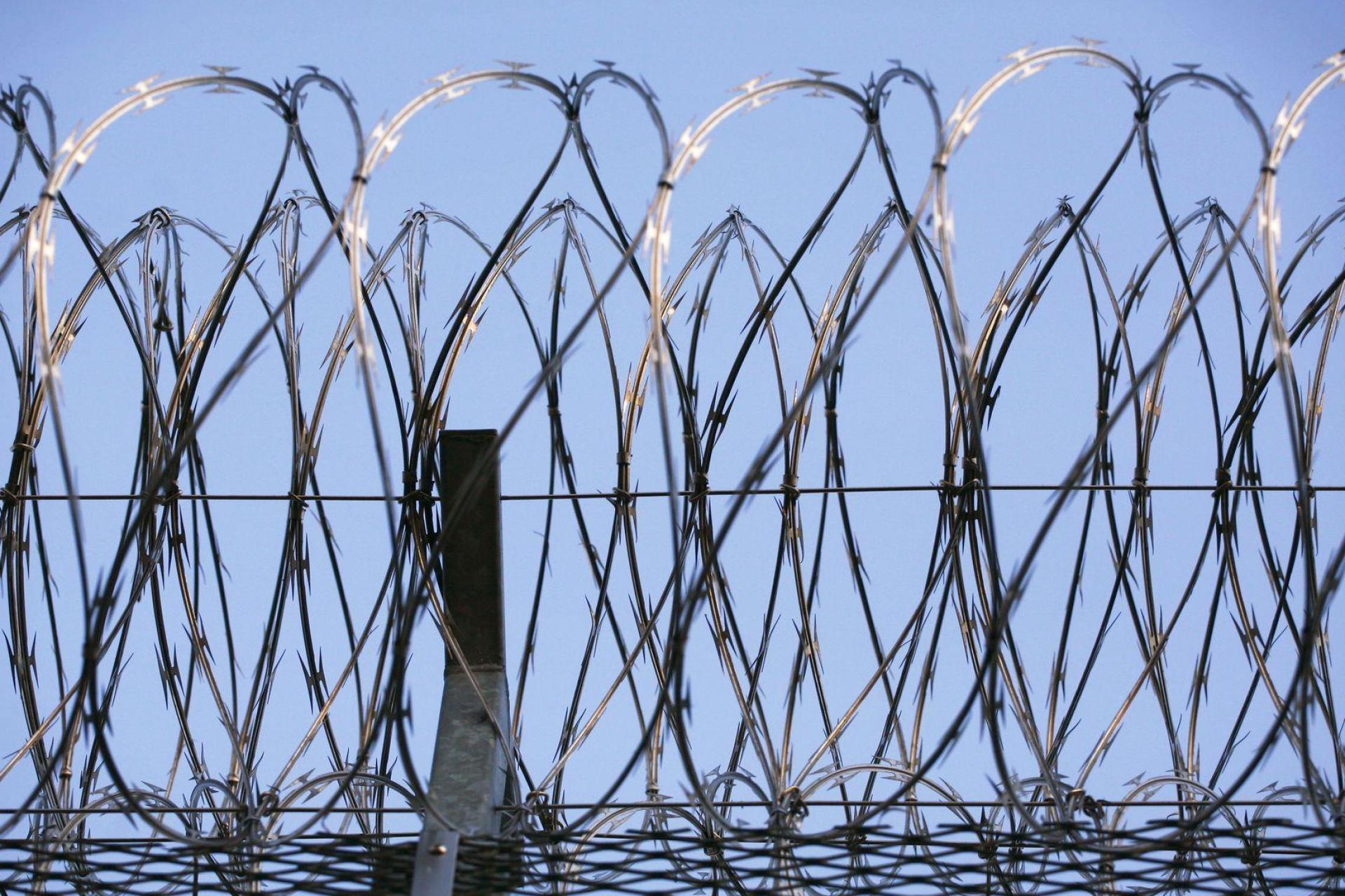 Stacheldraht krönt den Zaun eines Gefängnisses. In Landshut verhindert eine Spezialeinheit der Polizei die Befreiung eines Gefangenen. (Symbolbild: Wolfram Steinberg/dpa)