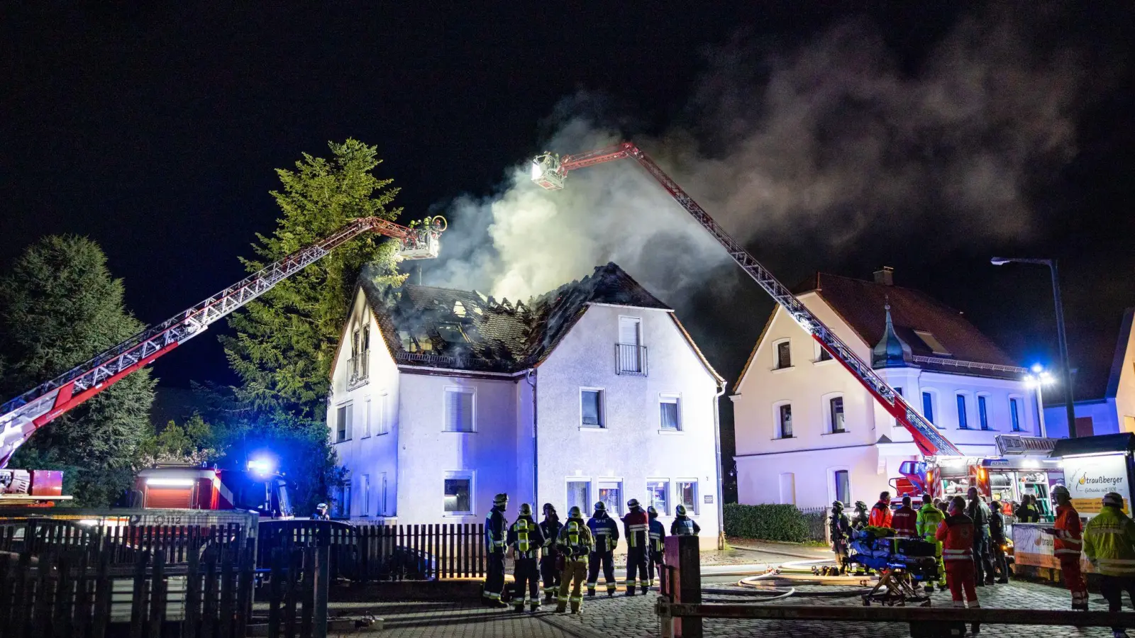 Einsatzkräfte der Feuerwehr sind mit einer Drehleiter am Brand eines Dachstuhls in Nürnberg beschäftigt. (Bild: David Oßwald/NEWS5/dpa)