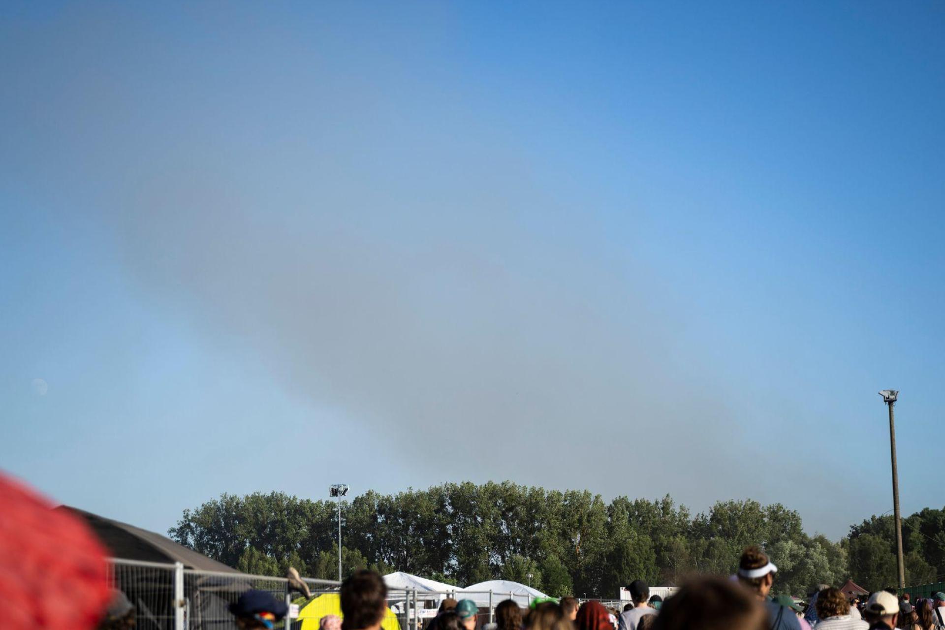 Eine Rauchsäule steigt unweit des Festivalgeländes in die Luft.  (Bild: Philip Dulian/dpa)