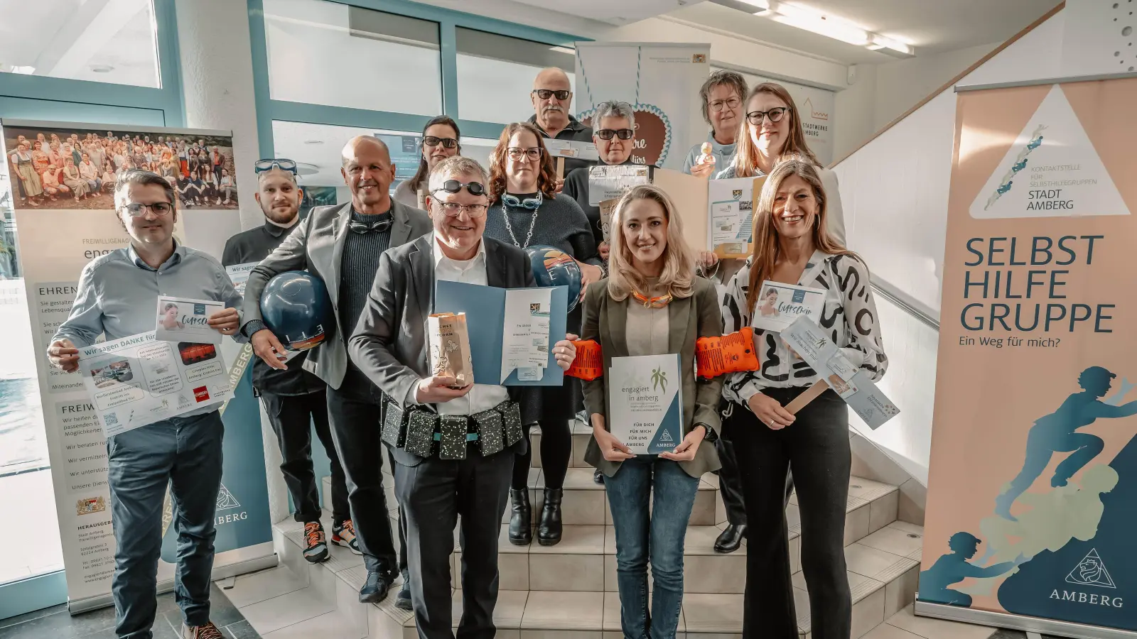 Die Beteiligten der Stadt Amberg, aus der Freiwilligenagentur, den Stadtwerken und dem Cineplex-Kino stellten mit Schwimmutensilien und Popcorn im Kurfürstenband die Aktionen rund um den Internationalen Tag des Ehrenamts vor. (Bild: Thomas Graml, Stadt Amberg)