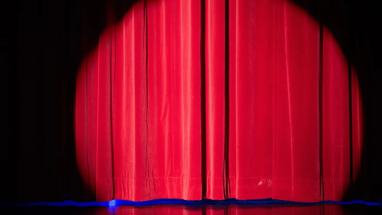 Noch ist der Vorhang zu. Doch bald beginnt die Vorstellung. Und dann heißt es – Handy aus und Blick auf die Bühne.  (Symbolbild: Sebastian Kahnert/dpa)