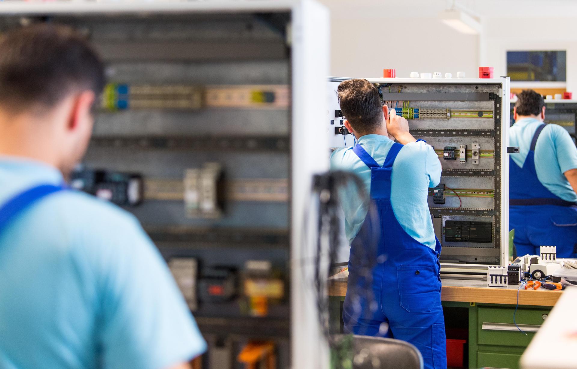 Auszubildende arbeiten an der Verdrahtung eines Schaltschranks. (Symbolbild: Monika Skolimowska/dpa)